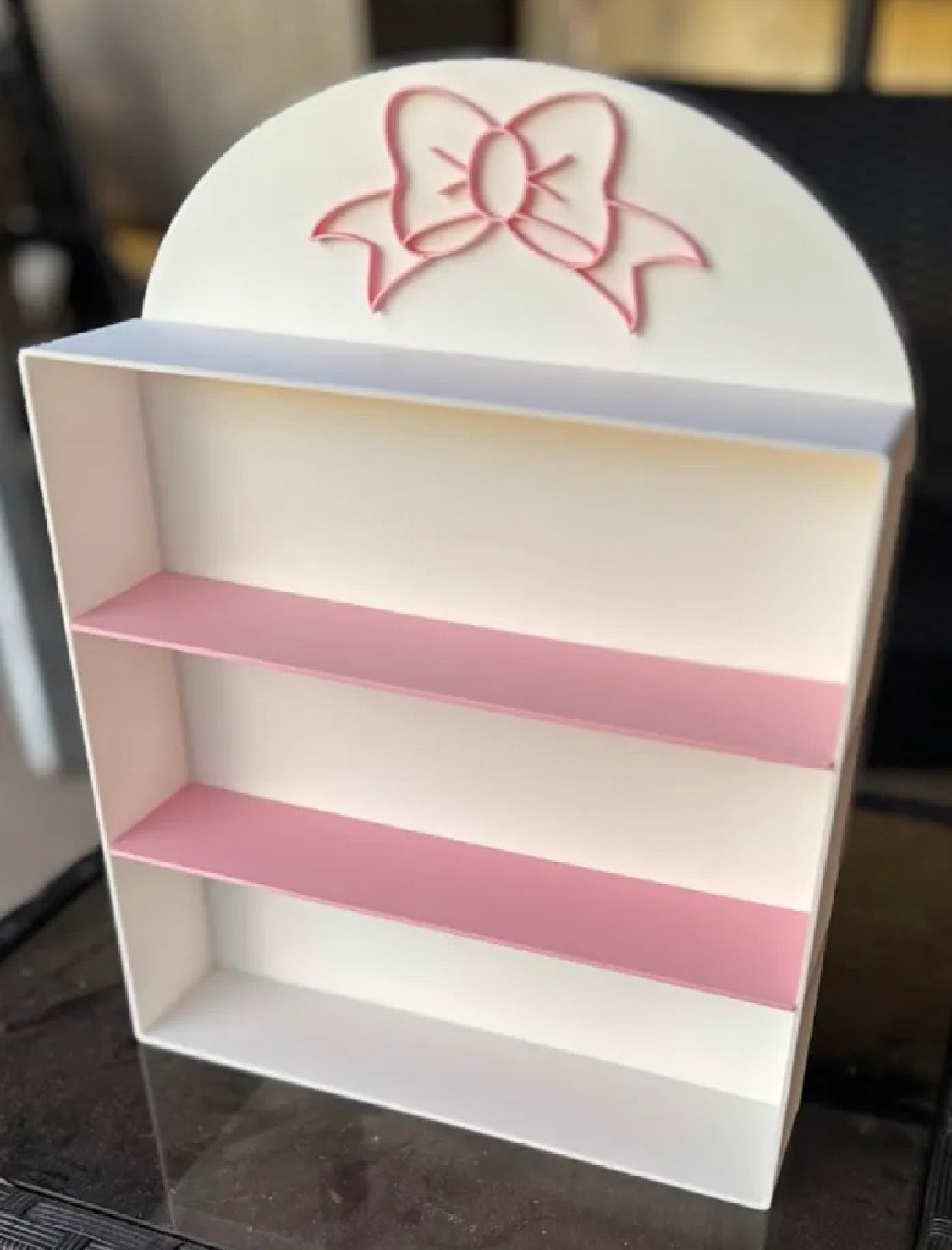 Coquette bow display shelf — angled view showing bow detail and pink shelves