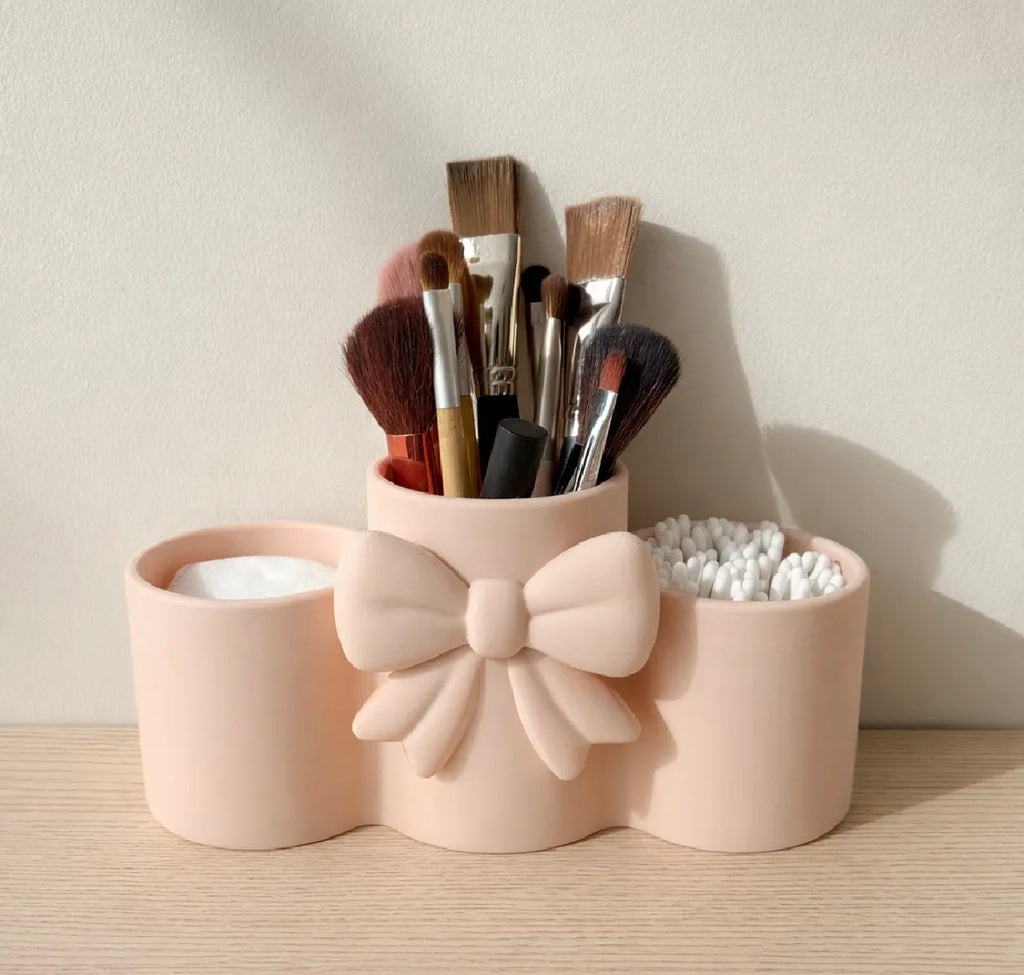 Coquette bow makeup brush holder in blush pink — filled with makeup brushes and Q-tips