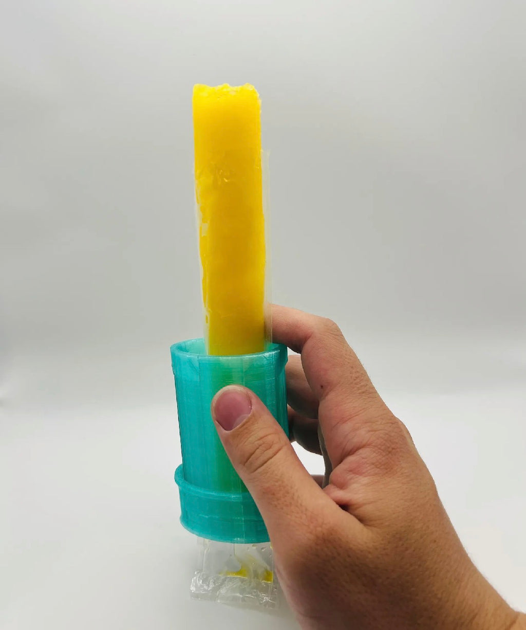Hand holding teal freeze pop holder with yellow freeze pop inserted, showing size and grip