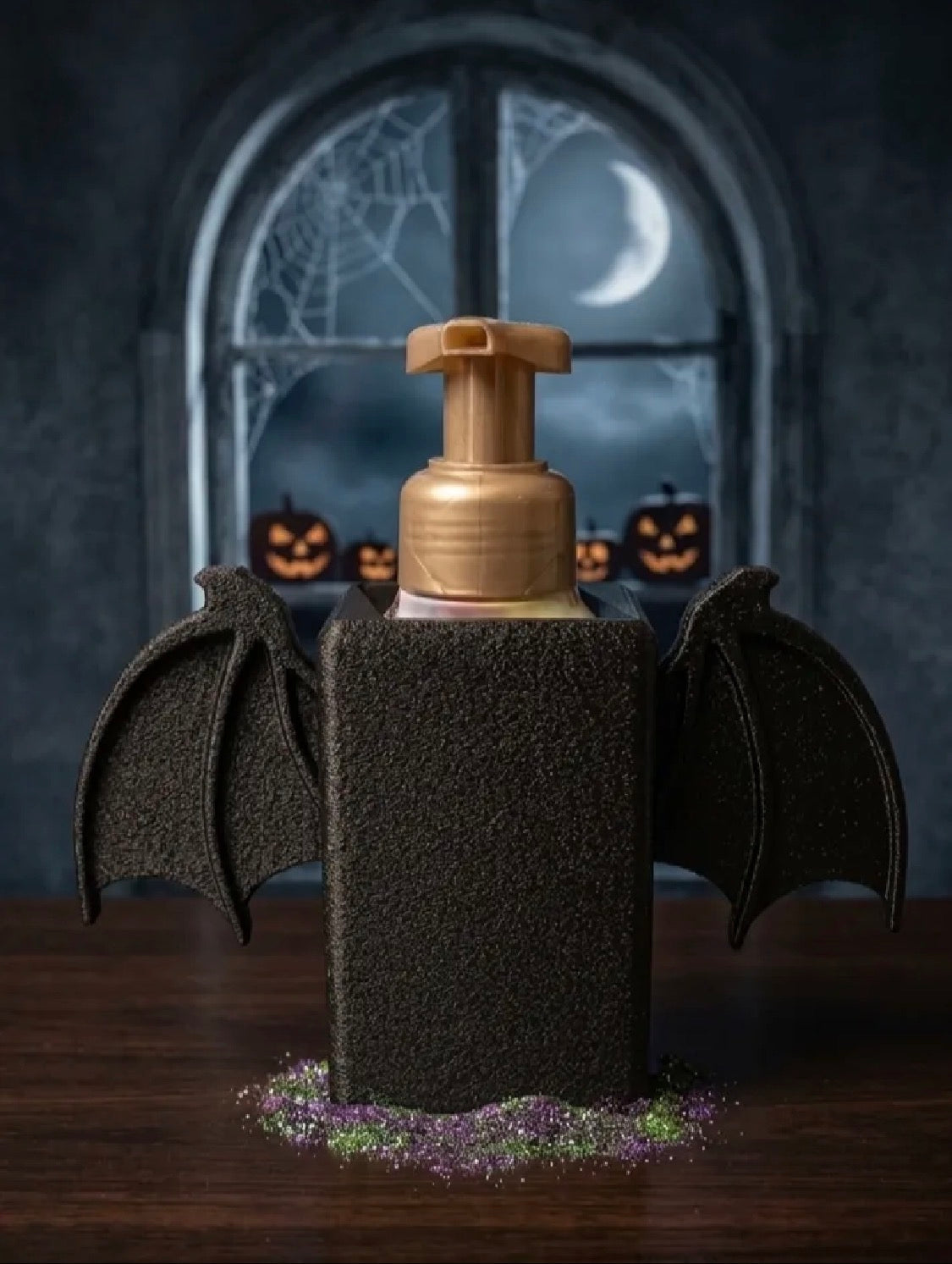 Bat wing soap dispenser holder Halloween lifestyle shot with moonlit window