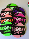 Colorful round Spooky Season Halloween signs with eye details, black bats, and scalloped black panels