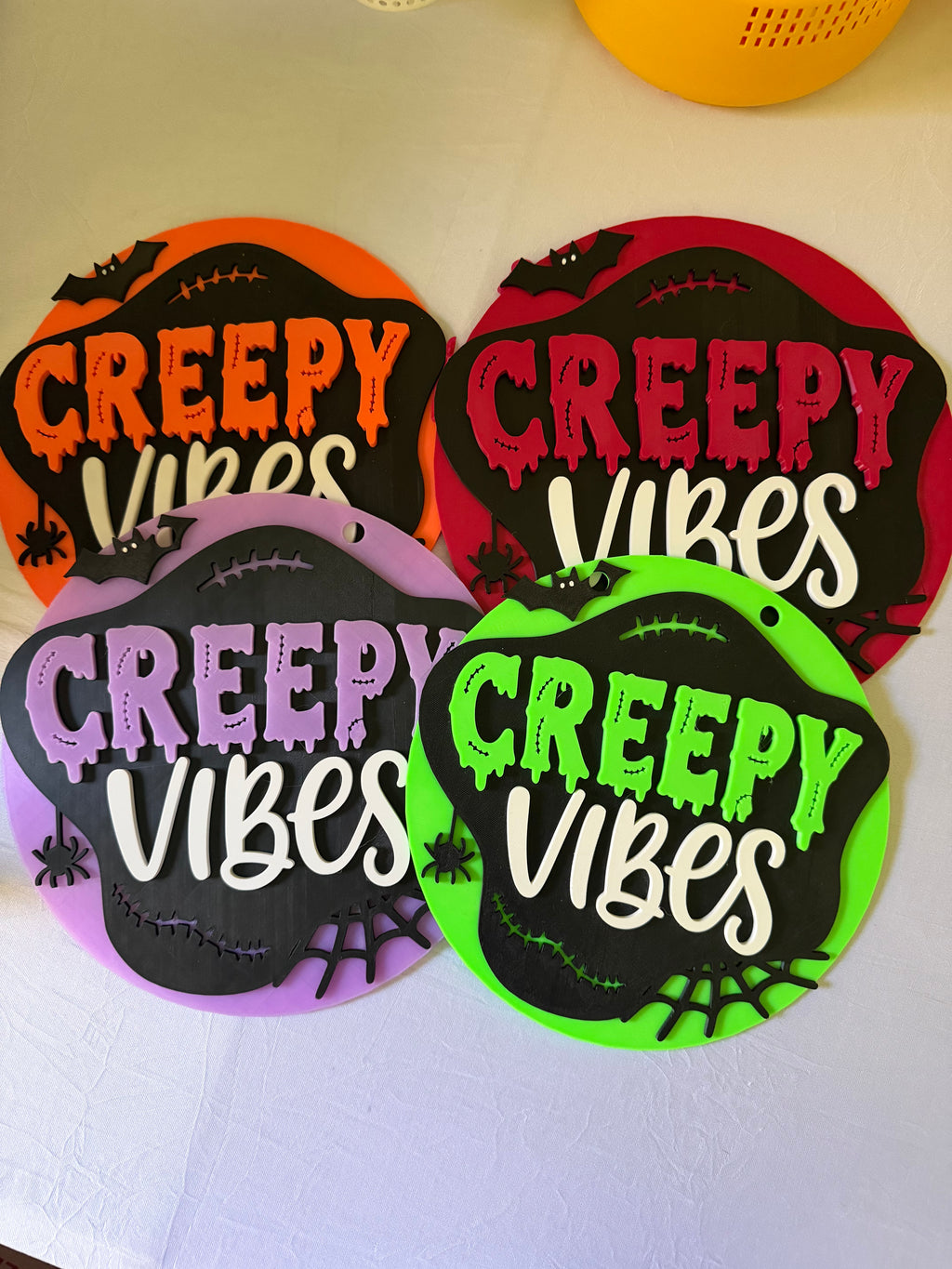 Orange, deep pink, lavender, and green Creepy Vibes round Halloween signs with bat and spiderweb accents