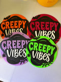 Orange, deep pink, lavender, and green Creepy Vibes round Halloween signs with bat and spiderweb accents