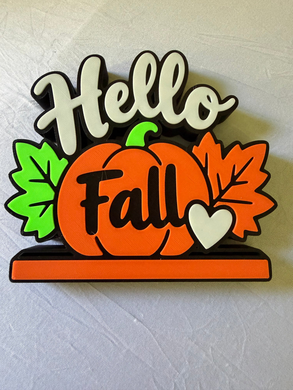 Detailed front view of Hello Fall sign with orange pumpkin, green and orange leaves, and cream heart