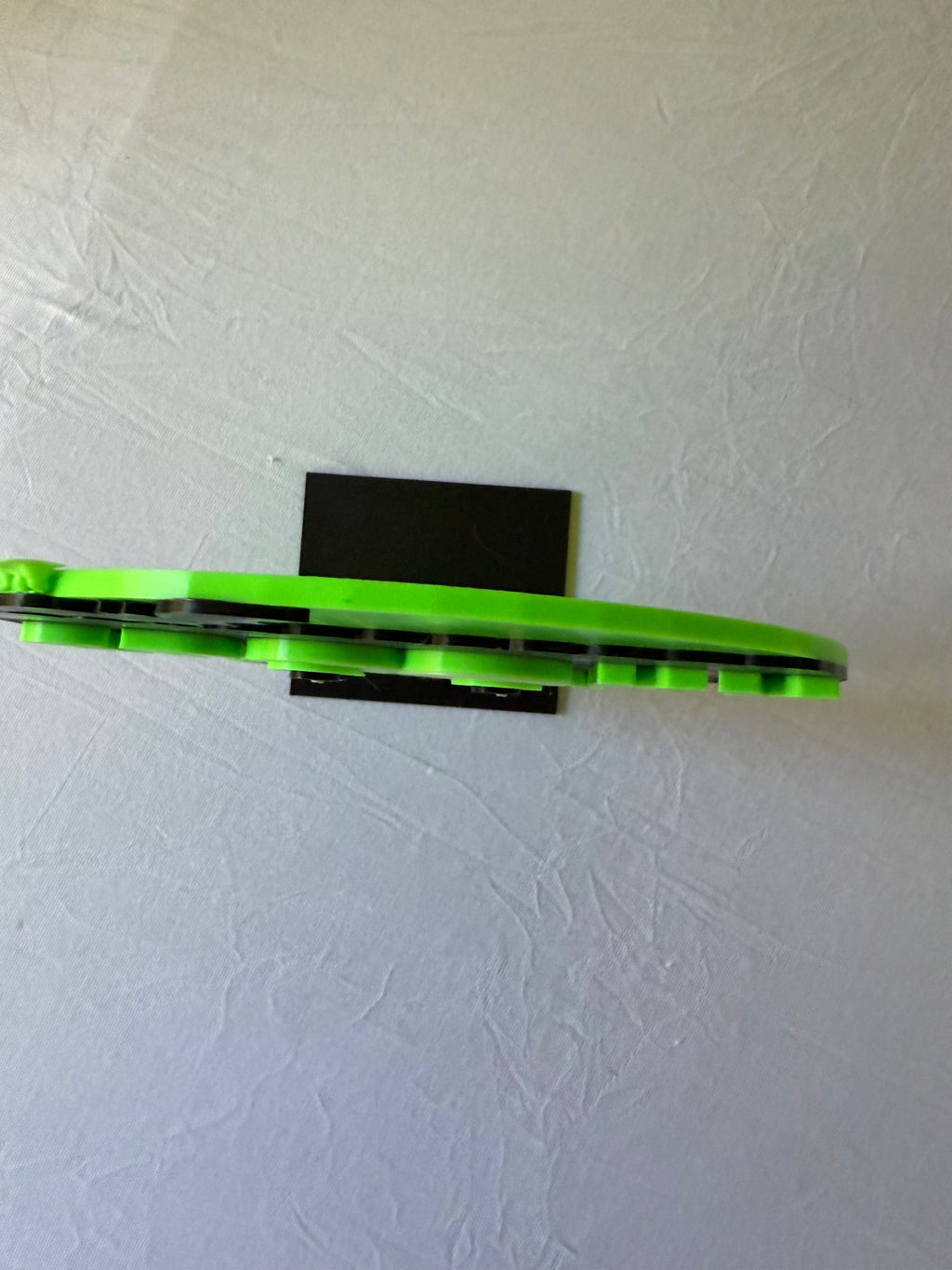 Side view of green Spooky Season sign showing layered thickness and black stand