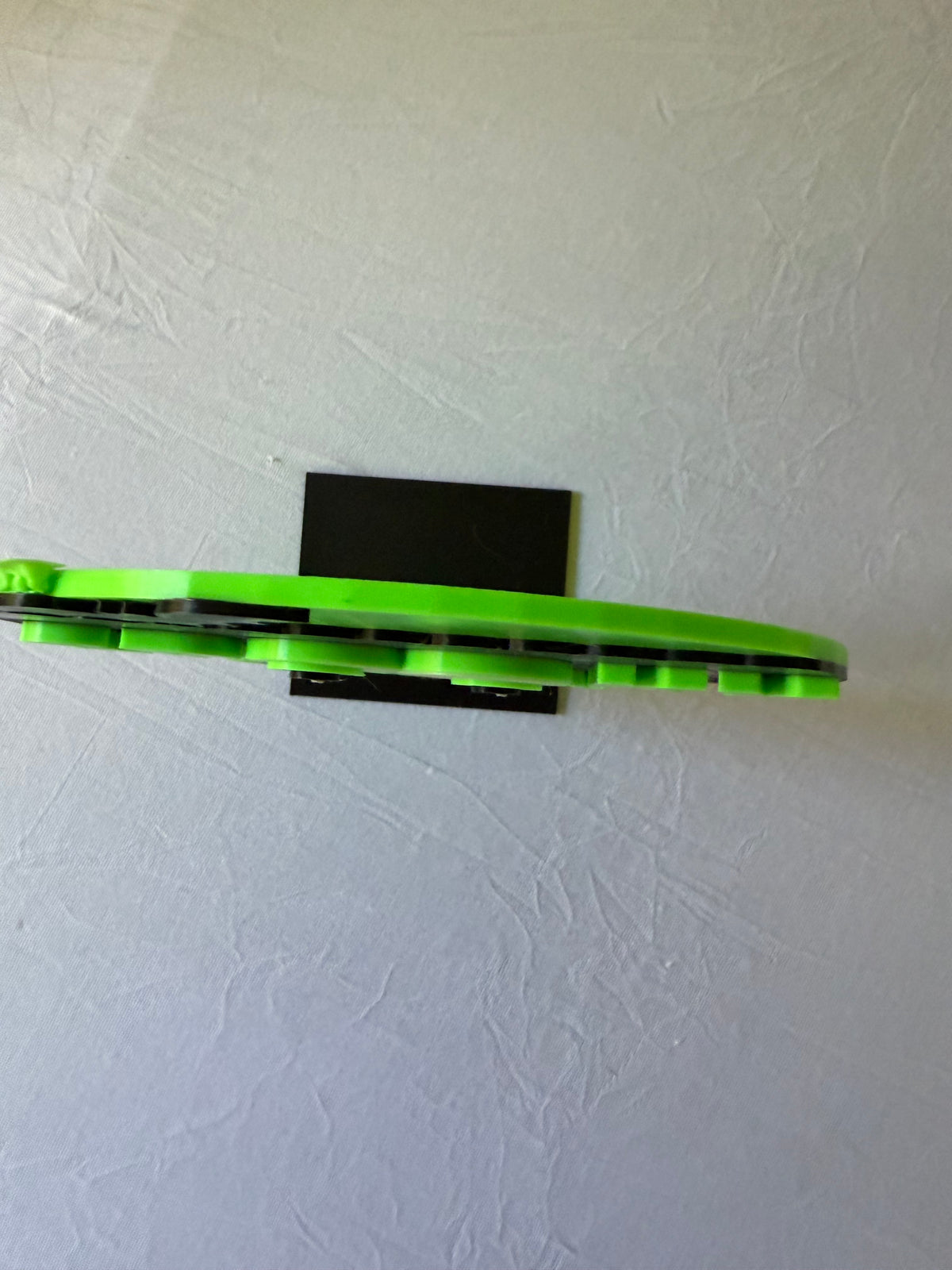 Side view of green Spooky Season sign showing layered thickness and black stand