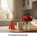 Red mini I Love You caution sign styled on kitchen counter with coffee mug and red roses