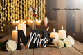 Black and white Mr and Mrs sign with bud vase styled at wedding reception with candles and roses