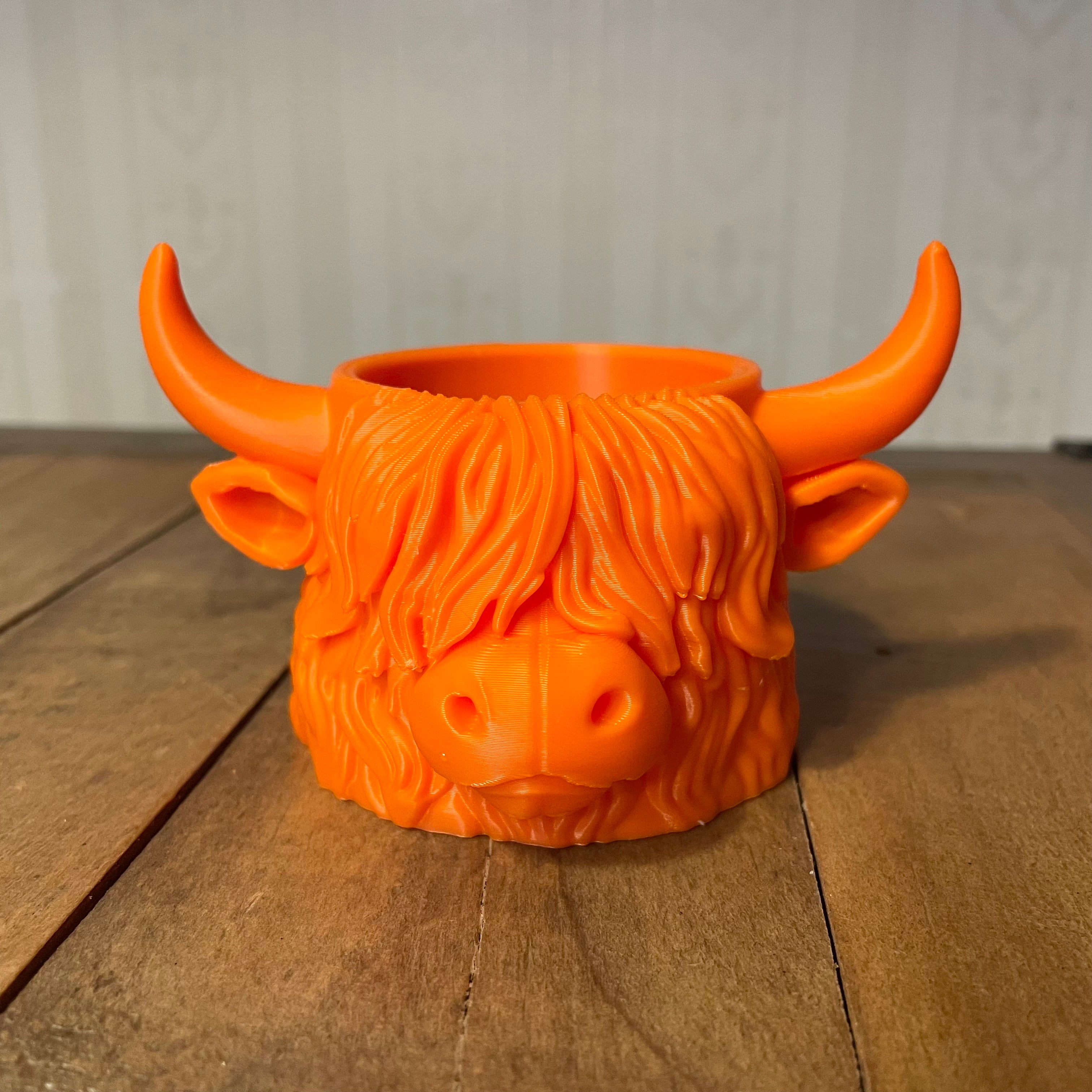 Orange Highland cow planter front view on wooden surface