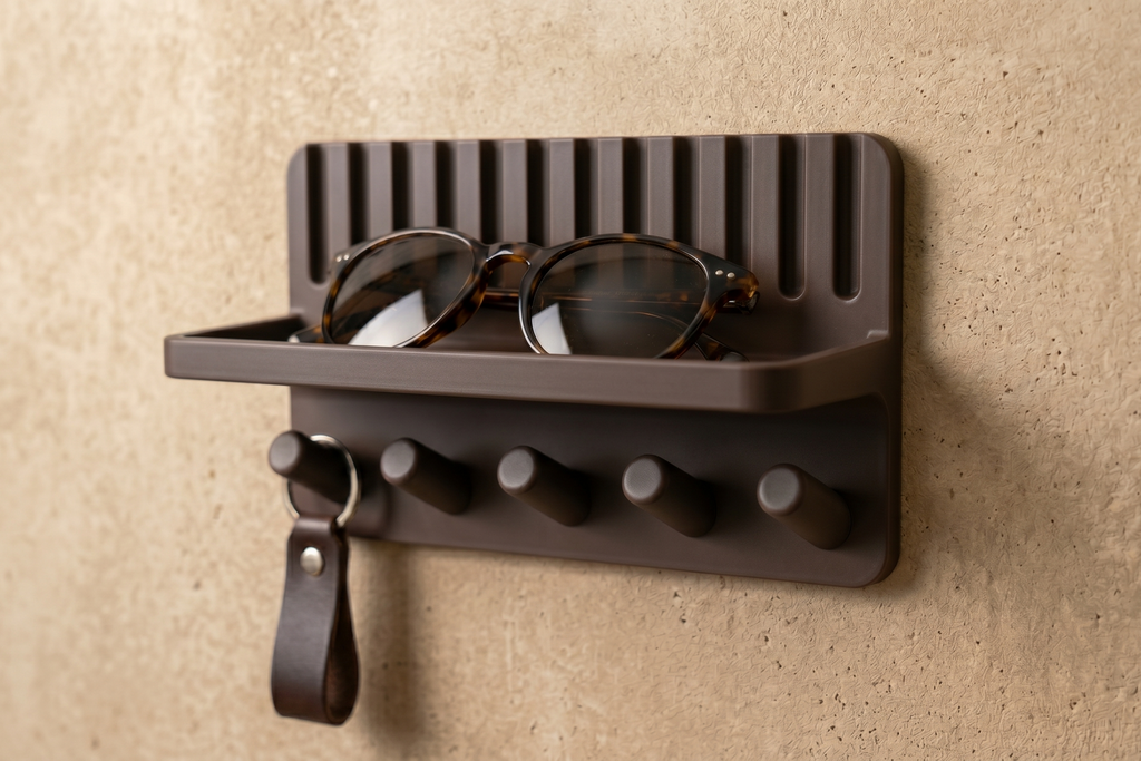 Entryway key holder shelf with keys hanging on pegs and sunglasses on tray, angled view