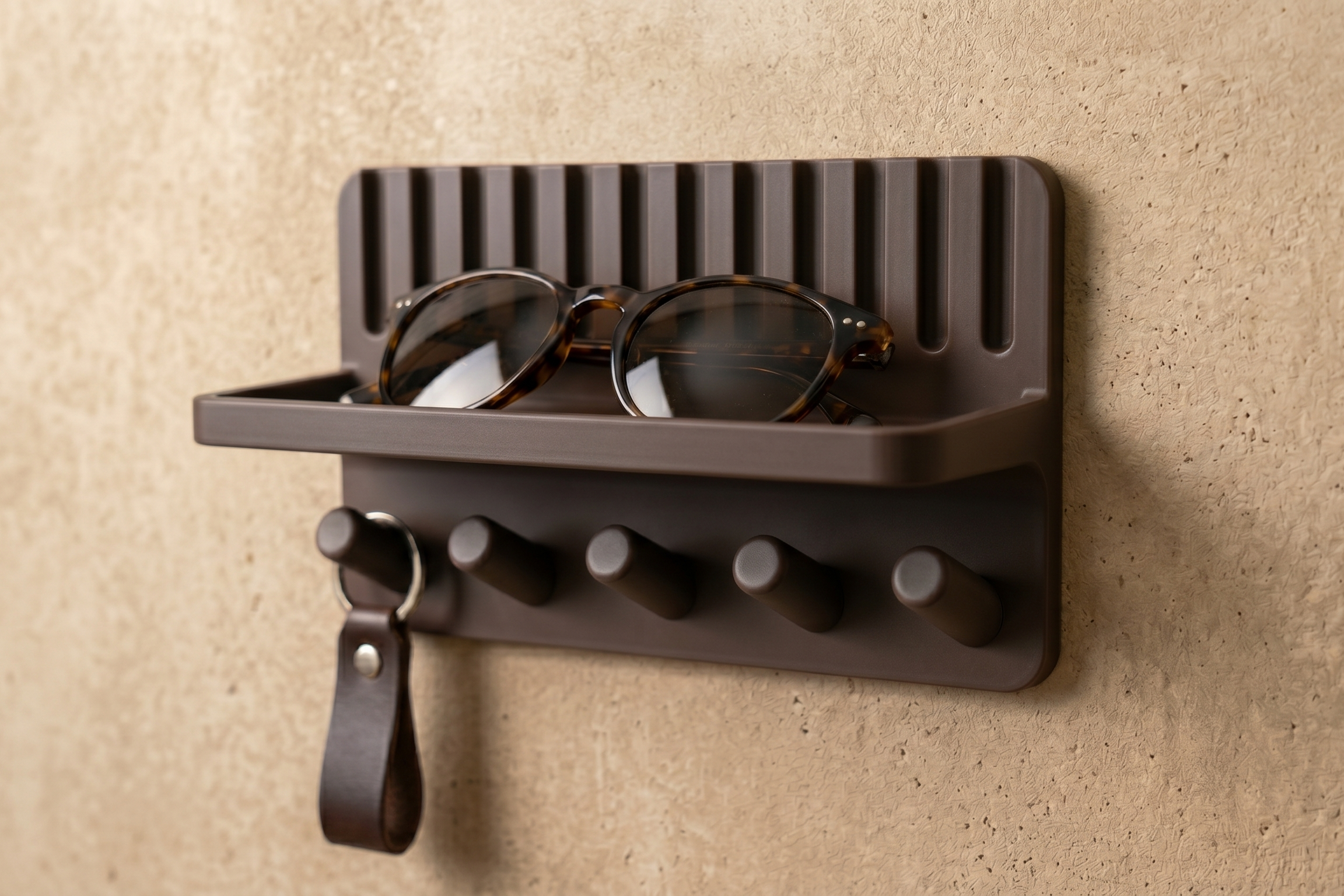 Entryway key holder shelf with keys hanging on pegs and sunglasses on tray, angled view
