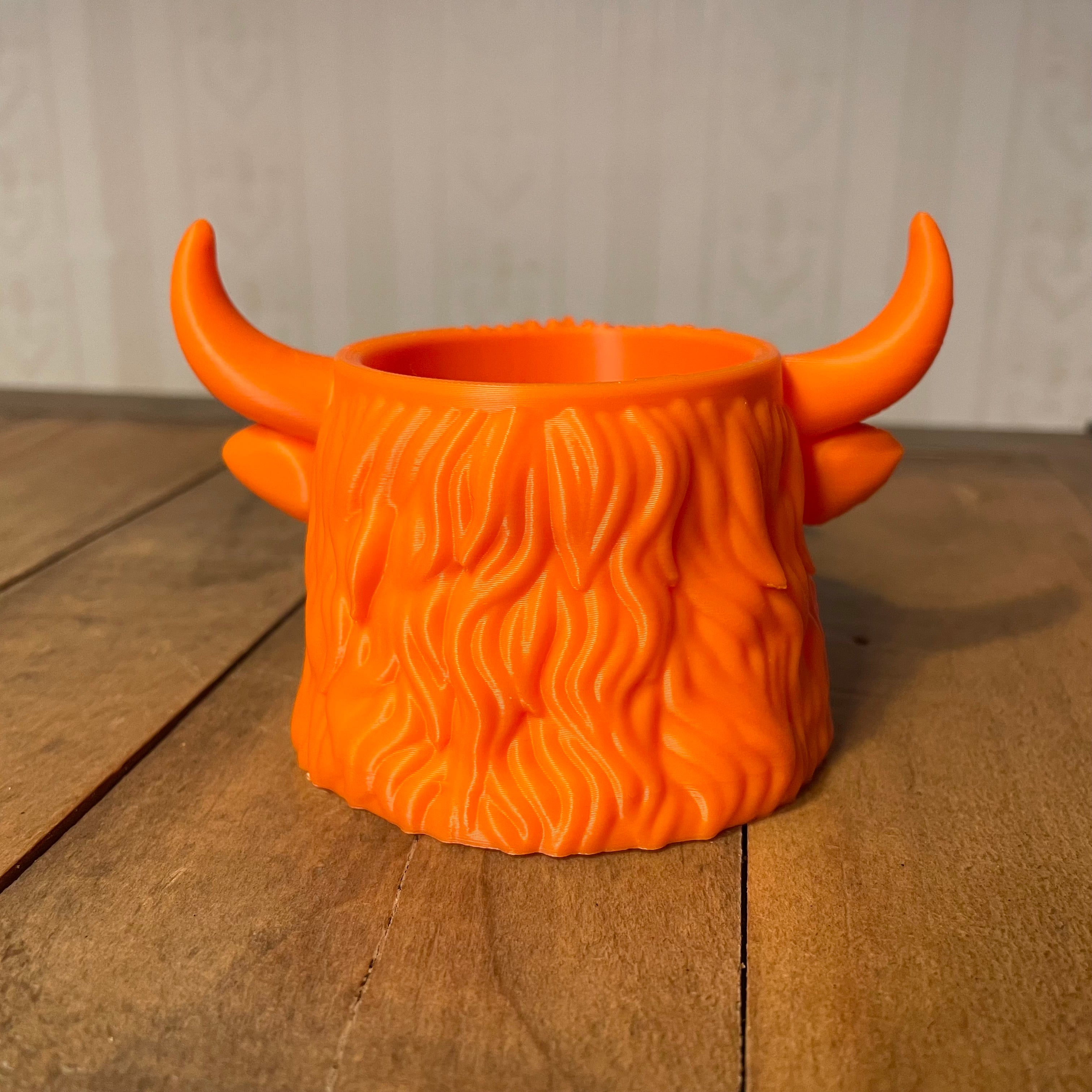 Orange Highland cow planter side/back view showing shaggy fur texture