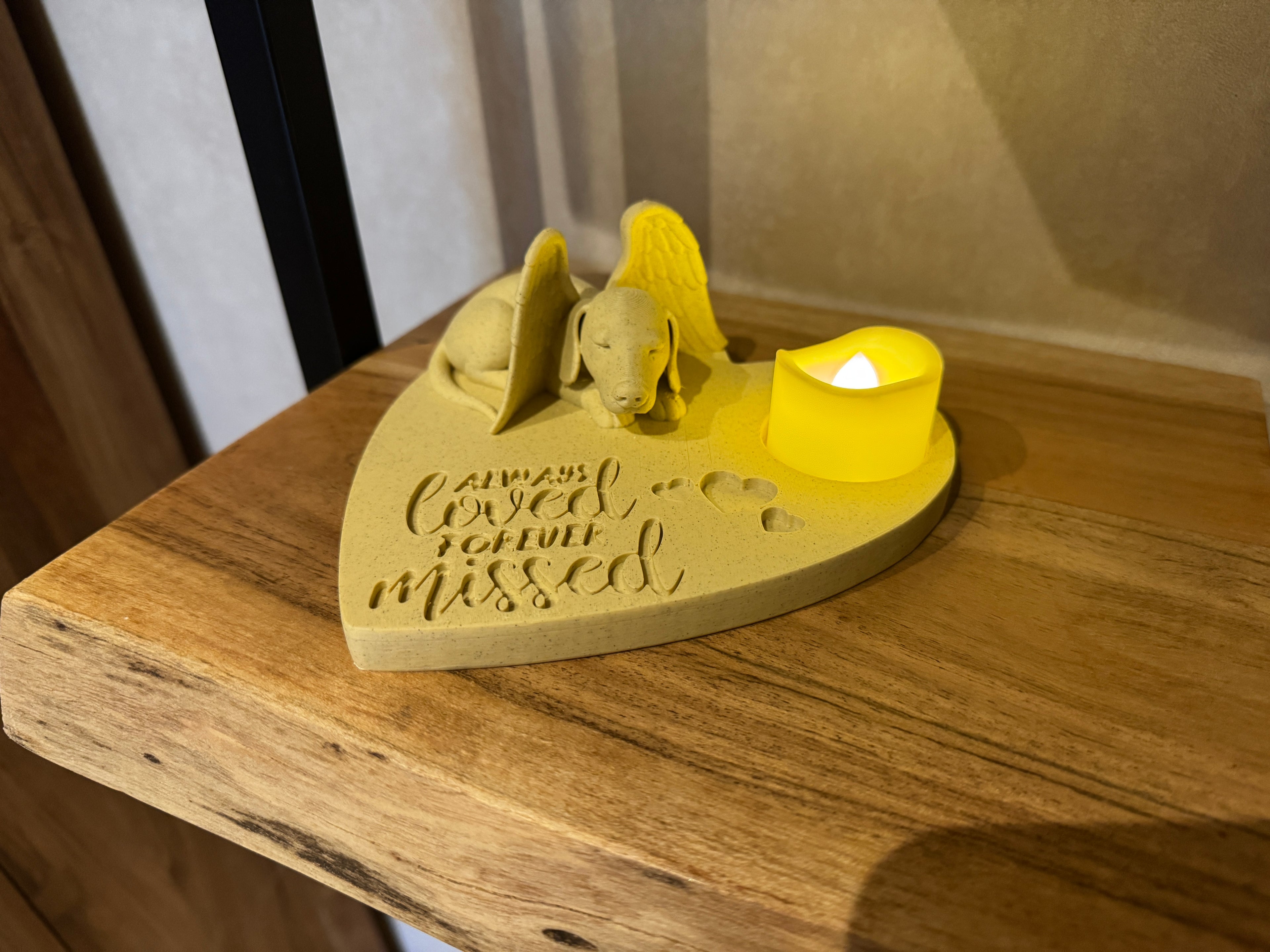 Dachshund angel memorial candle holder on shelf with warm candlelight