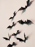 Set of 8 matte black 3D printed bat wall decorations arranged in a swooping flock pattern on a light wall