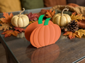 3D printed pumpkin napkin holder on wooden table with fall leaf and pumpkin decor