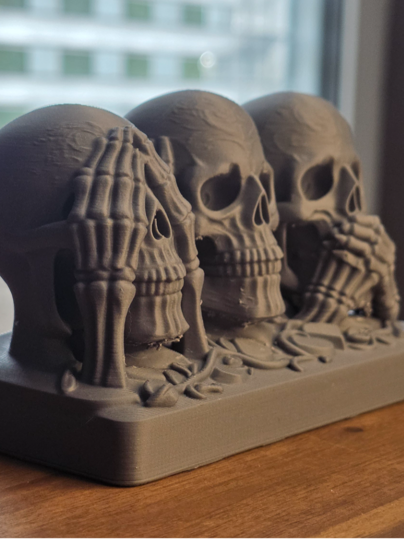 See hear speak no evil skull trio close-up showing detailed bone hand texture