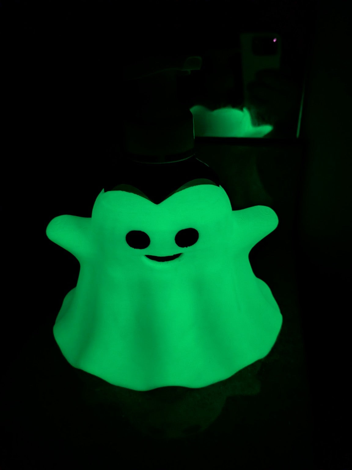 Glow in the dark ghost soap dispenser holder glowing green in the dark